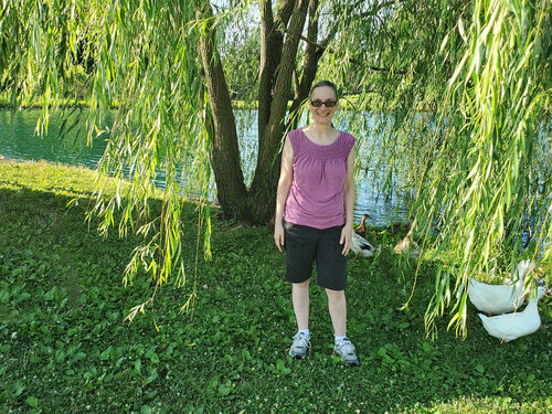 woman standing under willow tree