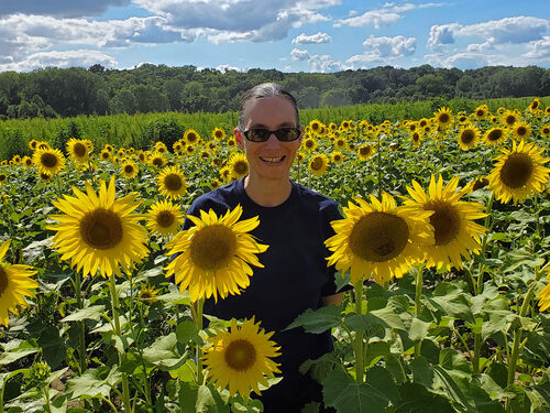 woman surrounded by field of sunflowers